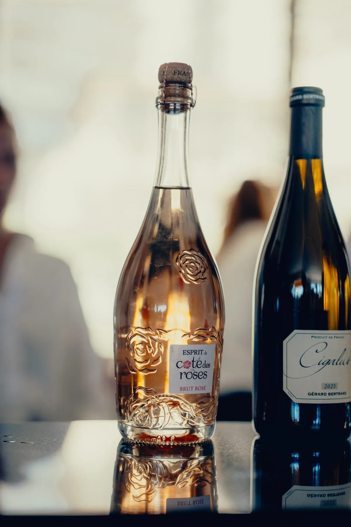 Bouteille de rosé pétillant et bouteille de vin rouge sur une table de réception